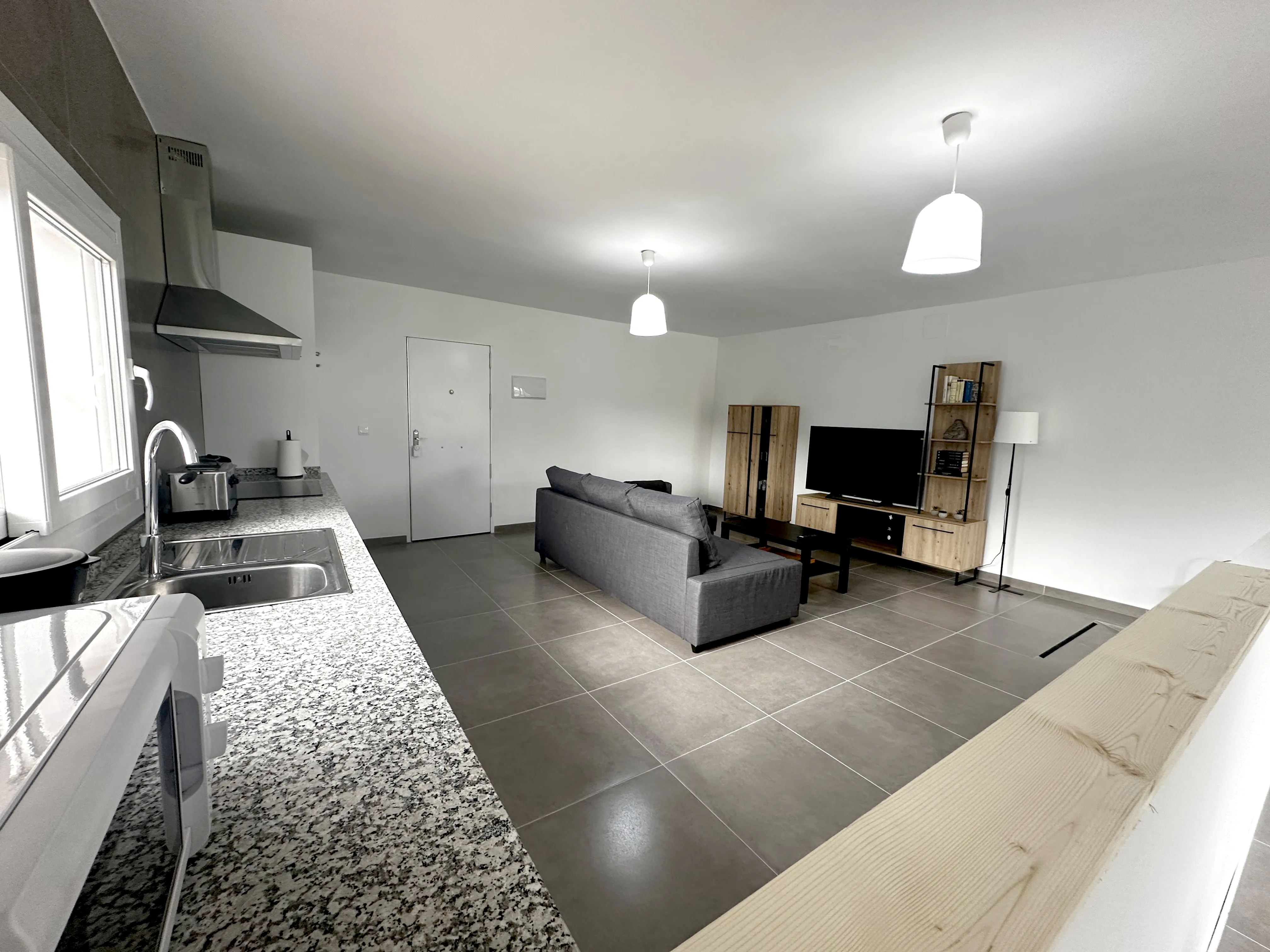 Salón comedor con cocina americana en apartamento Chiclana